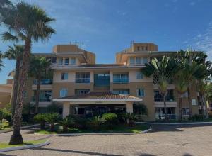 a large building with palm trees in front of it at The Sun Full Condominiun in Brasília