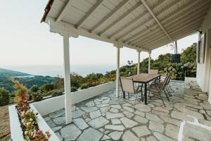 a patio with a table and chairs on top of a house at Little Villa in Makrirrákhi