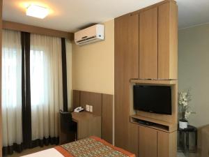 una camera d'albergo con una camera da letto con una TV e un letto di The Sun Full Condominiun a Brasilia