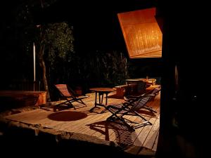 Enjoy Eco Lodge في Onhaye: مجموعة من الكراسي وطاولة على سطح خشبي