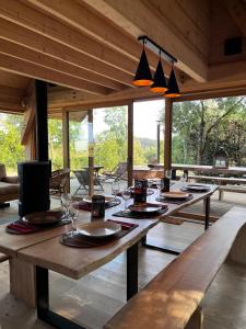 un comedor con mesas y sillas de madera y ventanas en Enjoy Eco Lodge en Onhaye