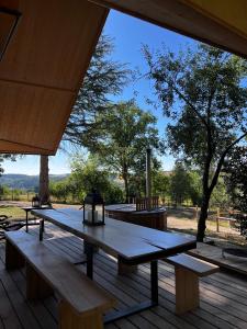 - une table de pique-nique sur une terrasse avec vue sur un champ dans l'établissement Enjoy Eco Lodge, à Onhaye