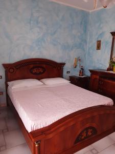 a bedroom with a wooden bed and a blue wall at Casa vacanze da Cinzia in Zanica