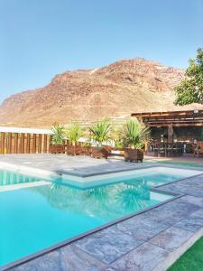 uma piscina com uma montanha ao fundo em F&C - Tranquilidad en mar y montaña em Las Palmas de Gran Canaria