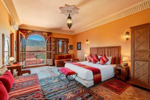 a bedroom with a bed and a large window at Kasbah Angour in Tahannout