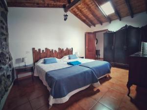 um quarto com uma cama grande e almofadas azuis em F&C - Tranquilidad en mar y montaña em Las Palmas de Gran Canaria
