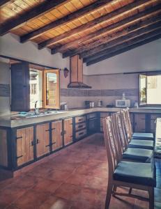 uma cozinha com armários de madeira e uma mesa e cadeiras em F&C - Tranquilidad en mar y montaña em Las Palmas de Gran Canaria
