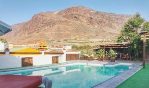 uma piscina com uma montanha ao fundo em F&C - Tranquilidad en mar y montaña em Las Palmas de Gran Canaria