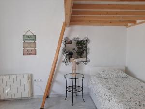 1 dormitorio con cama y escalera de madera en Apartamento luminoso casco antiguo San Luis, en Sevilla