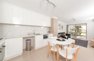 eine Küche und ein Wohnzimmer mit einem Tisch und Stühlen in der Unterkunft Yaran Suites in Rockingham