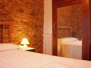 1 dormitorio con 2 camas y pared de ladrillo en Casa rural **** El Barreiro. Ideal para familias. en Sorbeda