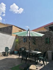 un tavolo e sedie con ombrellone su un patio di Domus de Jara - Casa Montis a Baradili