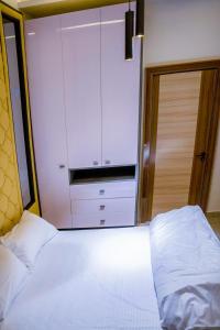 um quarto com um armário branco e uma cama em Plistbooking Xive 3 bedroom Luxury Abuja Apartment em Abuja