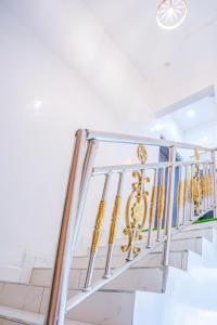 a metal staircase with gold railings in a house at Plistbooking Xive 3 bedroom Luxury Abuja Apartment in Abuja