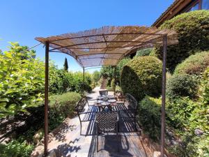 eine hölzerne Pergola mit einem Tisch und Stühlen darunter in der Unterkunft El Mirador del Chispano in Ayllón