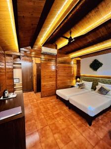 a bedroom with a large bed in a room with wooden walls at Beira Mar Beach Resort in Benaulim