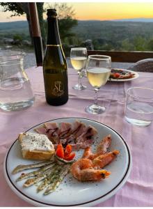 a table with a plate of food and a bottle of wine at Skalameri in Kozljak