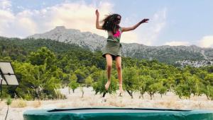 Ein Mädchen springt auf ein Trampolin in der Unterkunft Cortijo Blanco in Vélez-Blanco