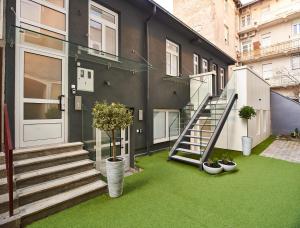 a house with a green yard with stairs and potted plants at Bed of Roses APT 1, Luxury, Designer decorated in Zagreb