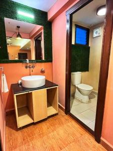 ein Badezimmer mit einem Waschbecken, einem WC und einem Spiegel in der Unterkunft Beira Mar Beach Resort in Benaulim