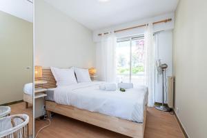 a bedroom with a large bed and a window at Amazing Sea View 2Bdr Swimming Pool Parking in Villefranche-sur-Mer