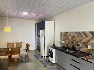 une cuisine avec un comptoir et une salle à manger avec une table dans l'établissement Casa para alérgicos, crianças, idosos e Pets., à Foz do Iguaçu