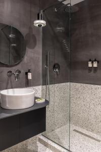 a bathroom with a sink and a glass shower at 72 AD Suites in Thessaloniki