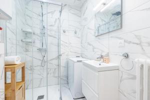 ein weißes Bad mit einer Dusche und einem Waschbecken in der Unterkunft Quiet 1 Bdr Downtown Terrace AC & Parking in Nizza