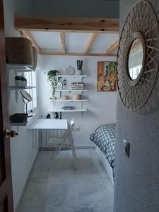 a room with a desk and a bed and a mirror at Apartamento luminoso casco antiguo San Luis in Seville