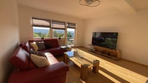 ein Wohnzimmer mit zwei Sofas und einem Flachbildfernseher in der Unterkunft Chebello in Koblenz