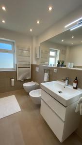 ein großes Badezimmer mit zwei Waschbecken und einer Toilette in der Unterkunft Chebello in Koblenz + 60 Fotos
