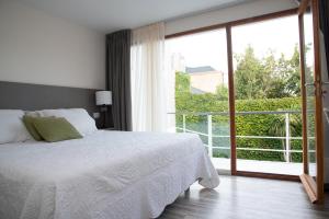 a bedroom with a bed and a large window at La Morada Petit Hotel in Neuquén