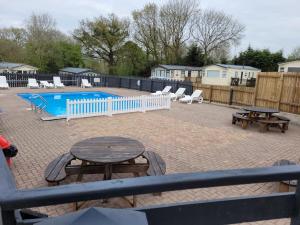a patio with a picnic table and a pool at Static Caravan KL13 in Bettws-Evan