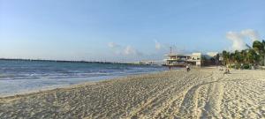 een strand met mensen en de oceaan en een pier bij Calaveritas Rooms in Playa del Carmen