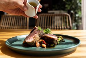 a person is holding a cup of tea next to a plate of food at Future Inn Cardiff Bay in Cardiff +73 photos