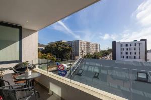 - Balcón con mesa y sillas en un edificio en Trendy Bachelor Pad Free Parking Rooftop Pool, en Ciudad del Cabo