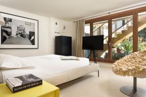 a bedroom with a bed and a tv in it at The Magic Forte in Forte dei Marmi