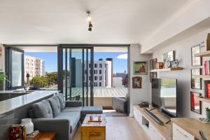 a living room with a couch and a large window at Trendy Bachelor Pad Free Parking Rooftop Pool in Cape Town