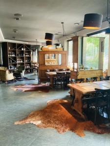 Willa Pastel في بياويستوك: غرفة كبيرة بها طاولات وكراسي وسجادة كبيرة
