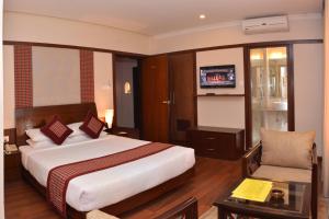 a hotel room with a bed and a chair at Hotel Marshyangdi in Kathmandu