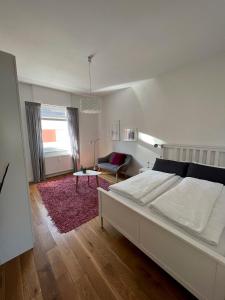 ein Schlafzimmer mit einem weißen Bett und einem roten Teppich in der Unterkunft Feel-Good Apartment In Mannheim-Neckarau in Mannheim