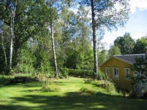 einen Hof mit einem Schuppen, einer Bank und Bäumen in der Unterkunft Almagården lantlig miljö in Svängsta