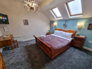 een slaapkamer met een bed, een bureau en een kroonluchter bij Stunning Luxury Vintage Duplex with Parking in Manchester