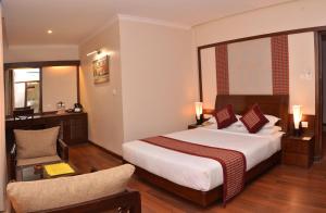 a hotel room with a bed and a chair at Hotel Marshyangdi in Kathmandu