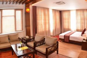 a hotel room with a bed and a living room at Hotel Marshyangdi in Kathmandu