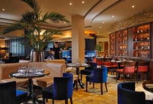 a restaurant with tables and chairs and a person in the background at Kilkenny Ormonde Hotel in Kilkenny