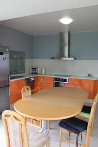 cocina con mesa de madera y sillas en Casa Frutales Escaselas, en Finisterre