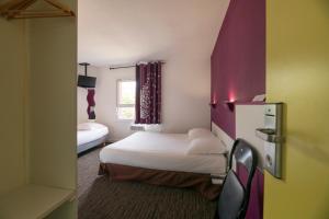 a small room with two beds and a window at Hôtel Cerise Auxerre in Monéteau