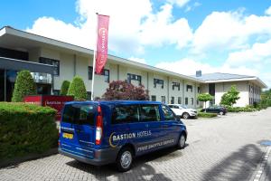 a blue van parked in front of a building at Bastion Hotel Schiphol Hoofddorp in Hoofddorp