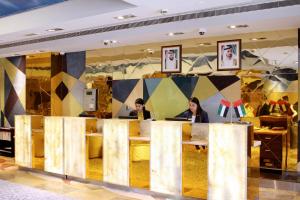 two people sitting at a counter in a store at The Leela Hotel in Dubai